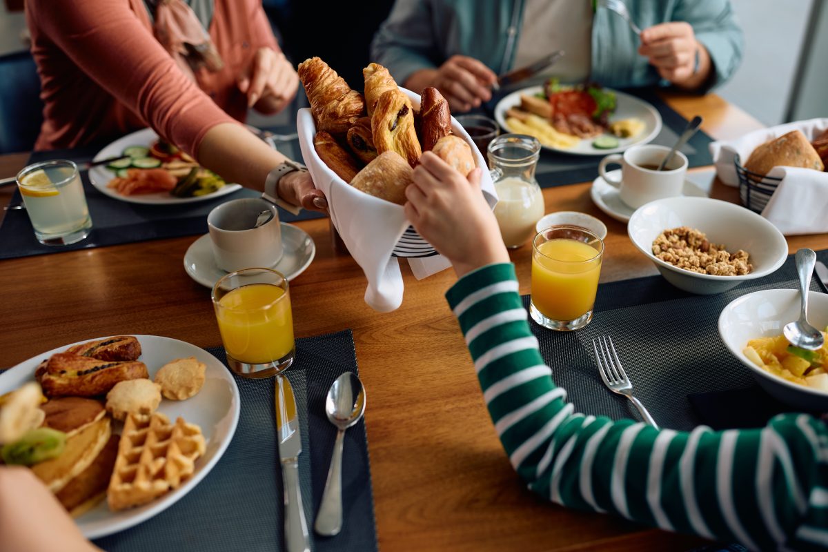 Close up of family having breakfast at dining table in a hotel.